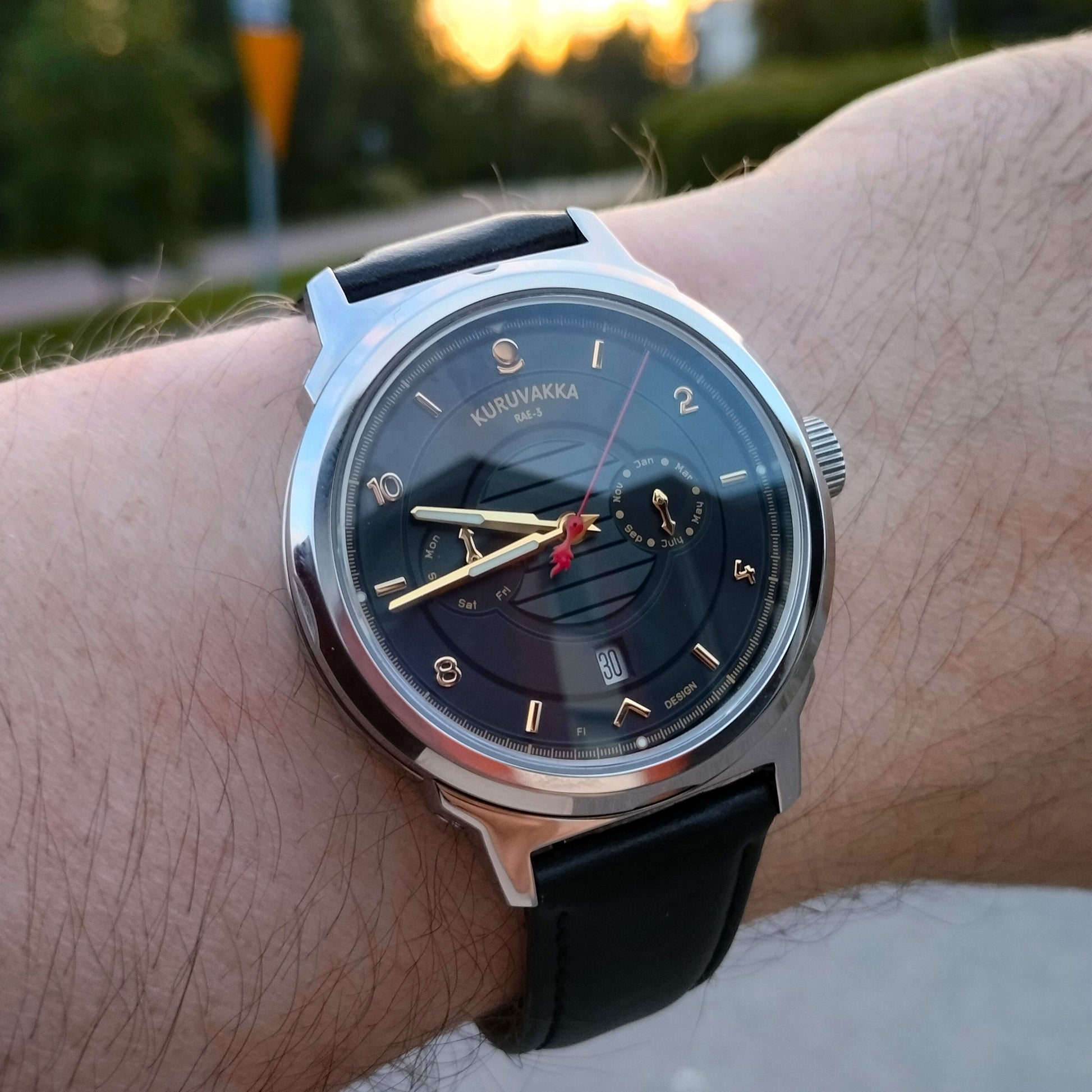 Kuruvakka RAE-3 watch on a wrist basking on the evening sun. Face slightly angled towards the camera, hands shining in shadow